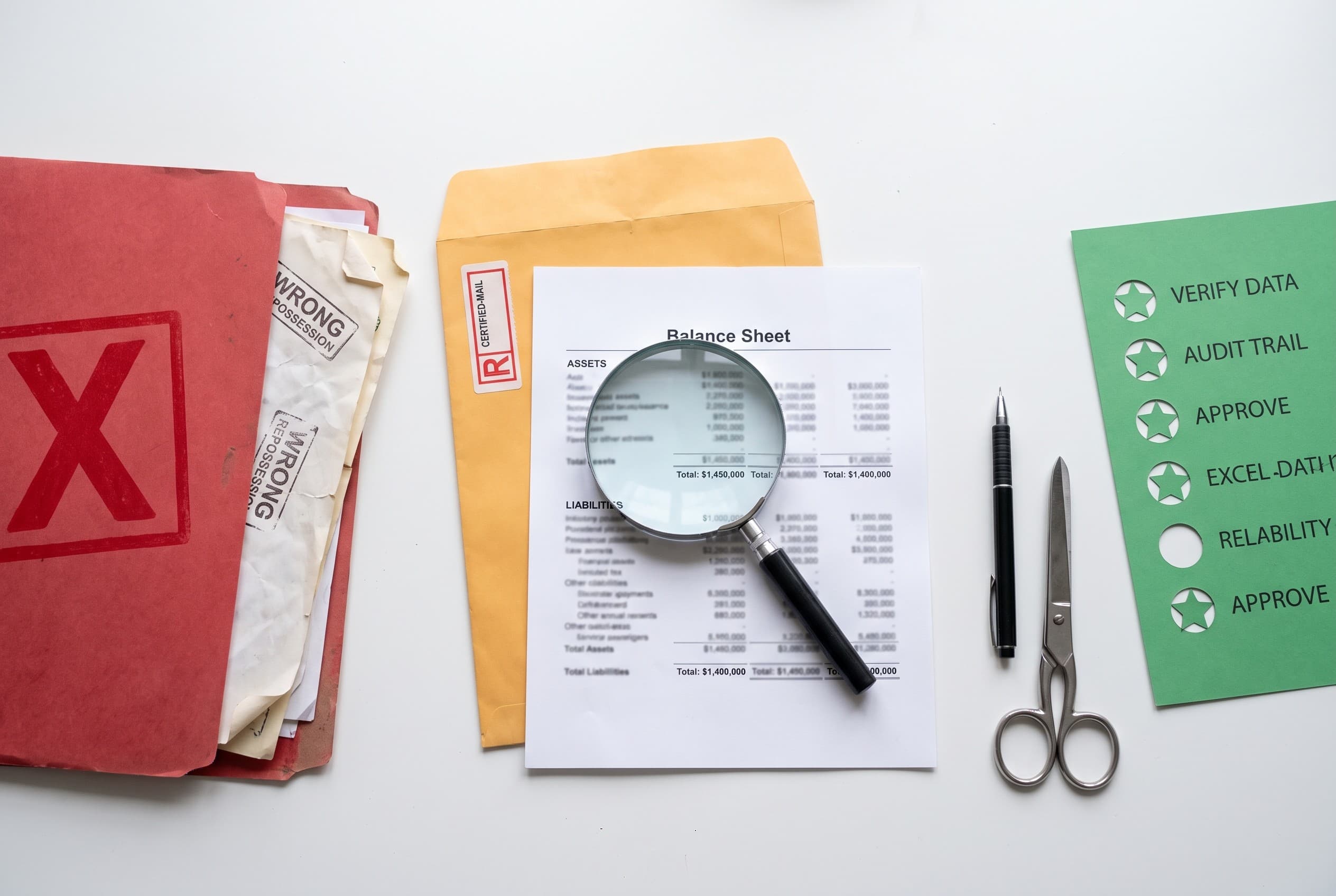 Top-down flat-lay photo on a clean white desk. On the left, a red folder with a bold stamped X, holding crumpled papers repre