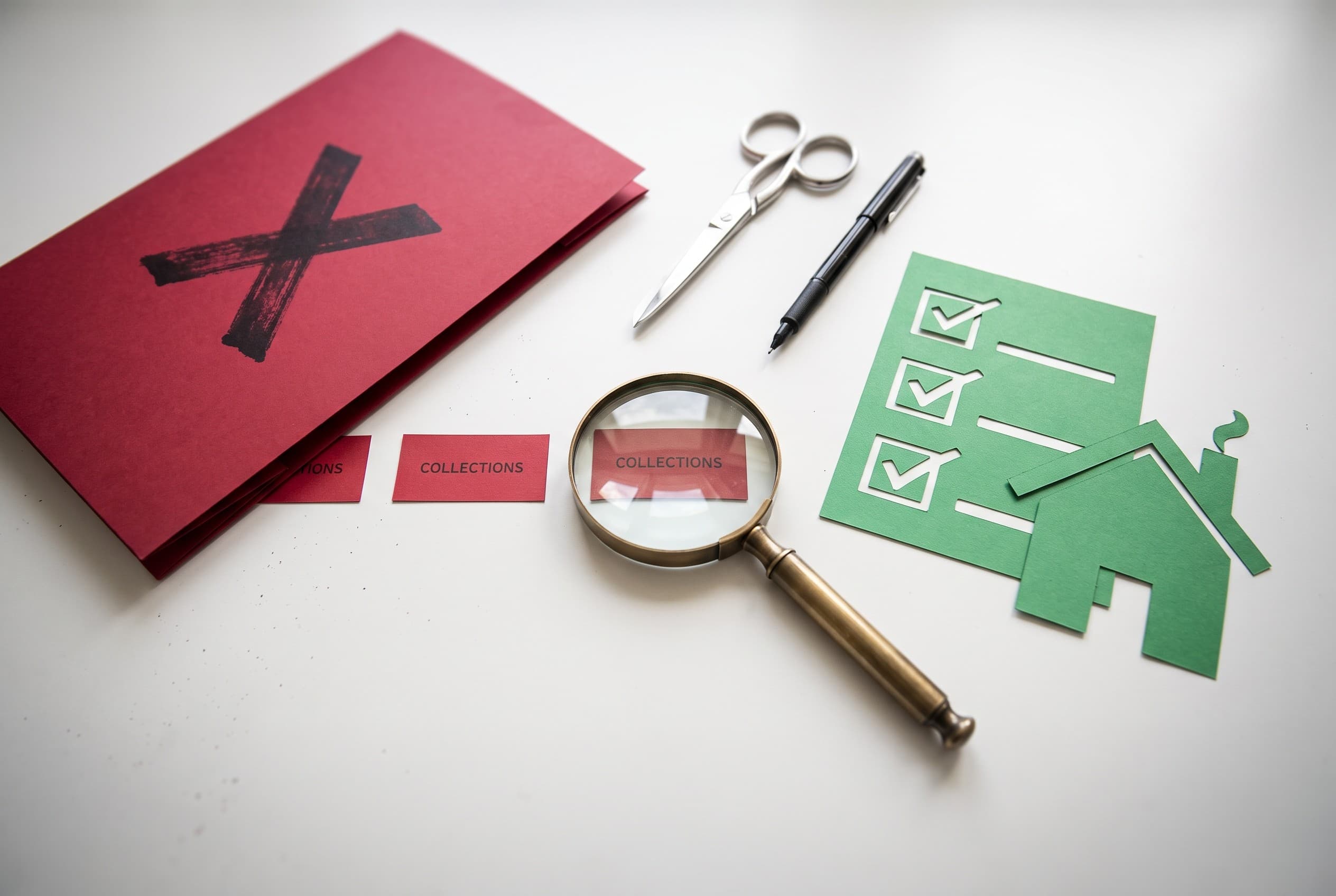 Top-down flat-lay photo of a clean white desk arranged to explain a mortgage denial cleanup. On the left, a red folder with a